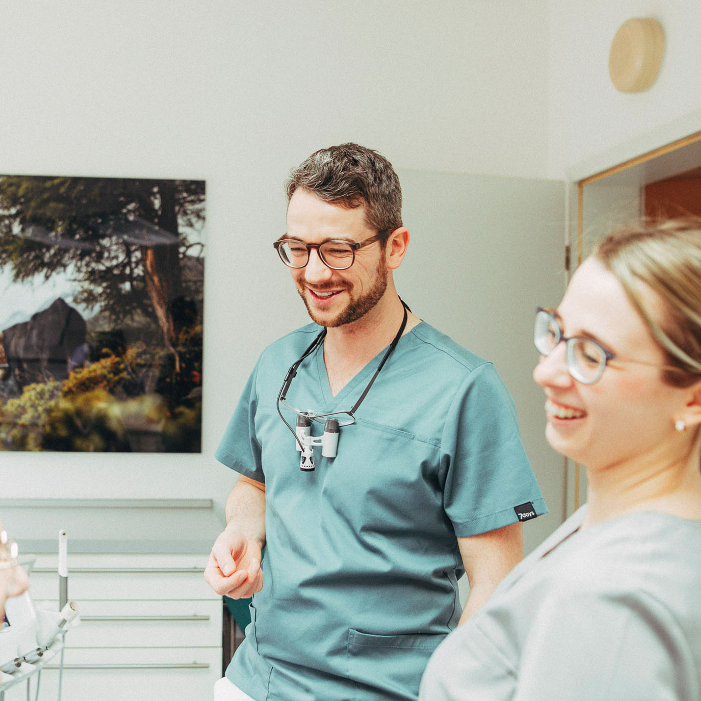 Christoph Bölich lacht mit einer Mitarbeiterin nach einer Behandlung ohne Bohren in der Zahnarztpraxis Christoph Bölich in Rötha