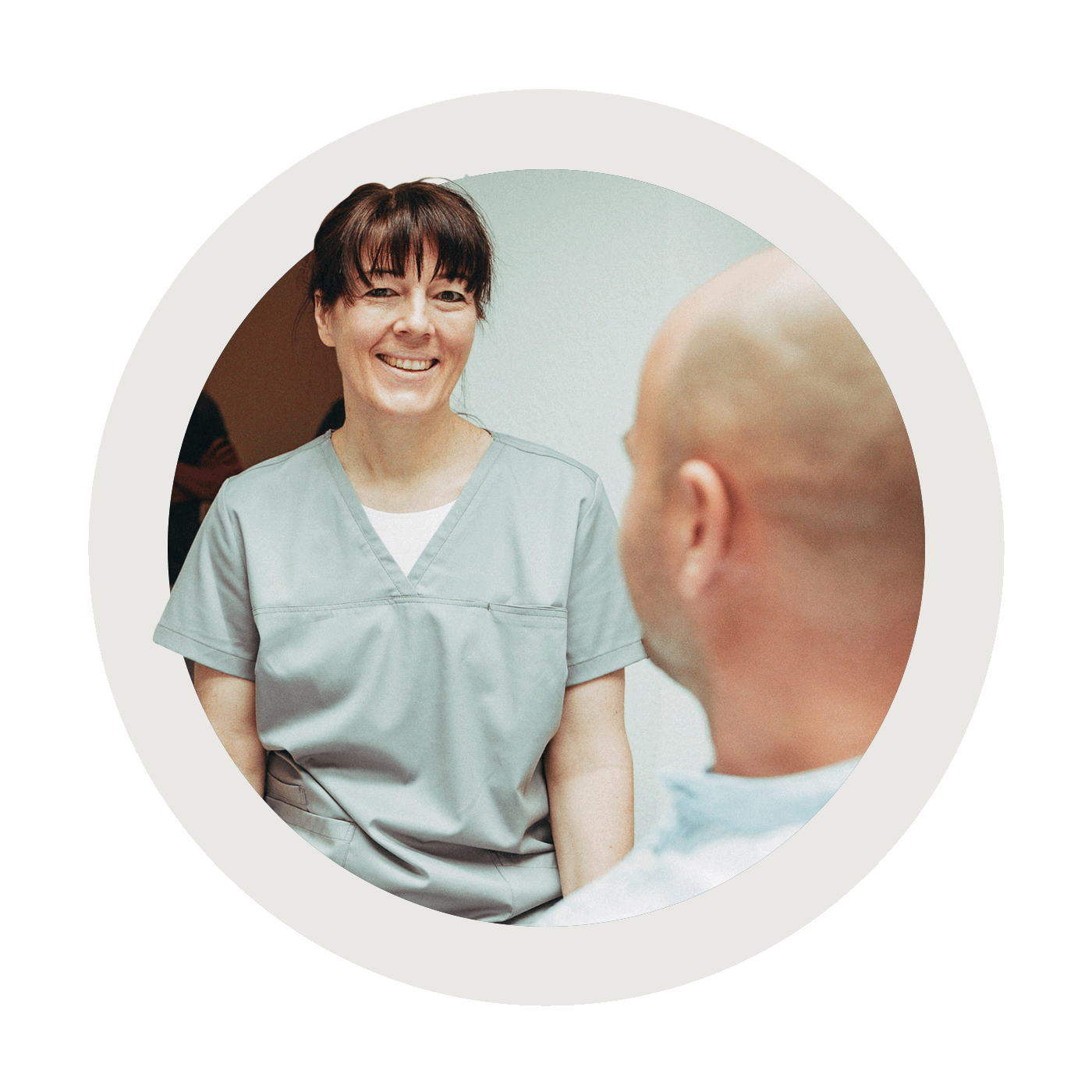 Eine Mitarbeitern lacht mit einem Patienten in einer Keramik-Behandlung in der Zahnarztpraxis Christoph Bölich in Rötha.